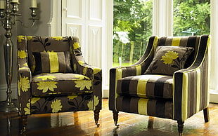two black and green fabric armchairs with throw pillows near glass wall HD wallpaper